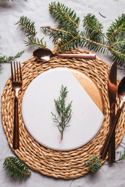 istock Christmas table settings with a wreath, pine branch and golden cutlery 1180382776