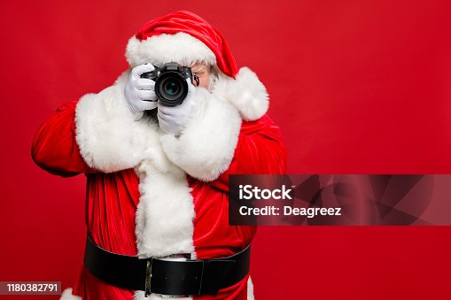 istock Portrait of focused elderly santa claus hipster take photo of his christmas time voyage abroad wear stylish costume belt gloves isolated over red background 1180382791