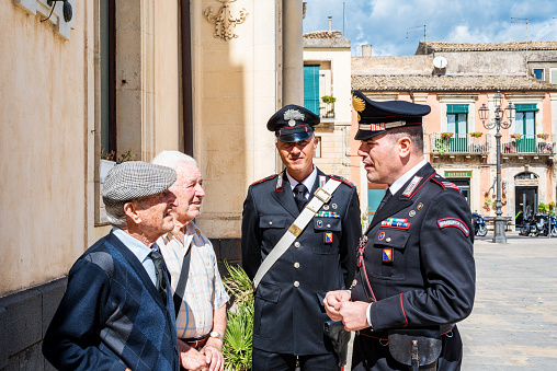 Syracuse Sicily/ Italy - october 04 2019: Carabinieri discuss with two elderly people in the town square