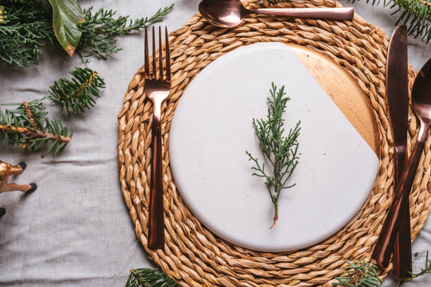 istock Christmas table settings with a wreath, pine branch and golden cutlery 1180382898