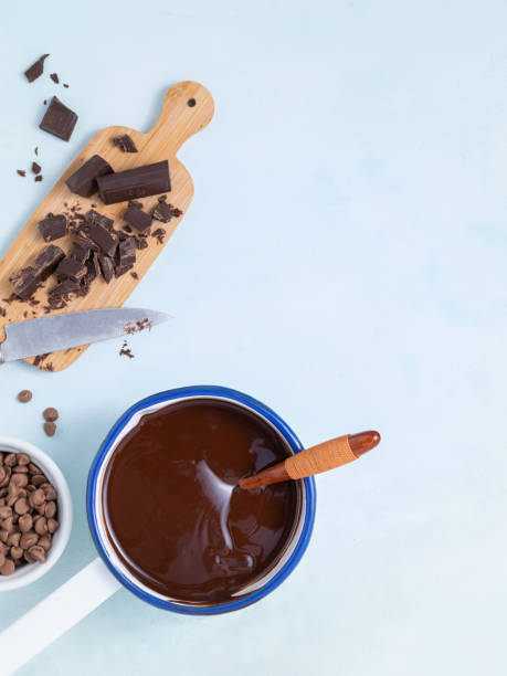 istock Molten chocolate with different types of chocolate for dough preparation recipe chocolate ganache, cake, brownie, muffins, cupcakes ingridients, food flat lay on light background. Text space. 1180384264
