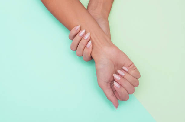 istock Stylish trendy female manicure. Beautiful woman's hands on soft background. 1180384406
