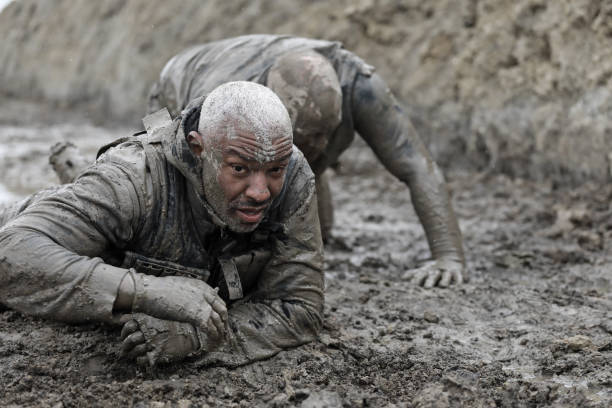 military mud run crawling exercise - mud run imagens e fotografias de stock