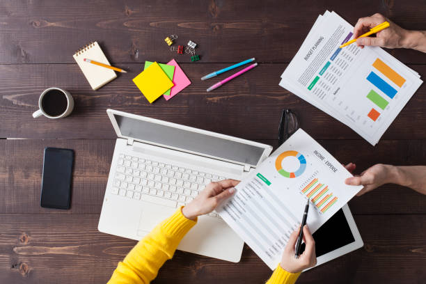 istock Two people working on desk at office. Overhead shot. 1180386713