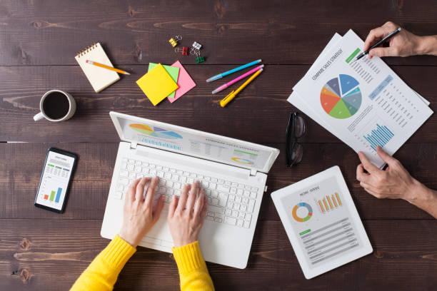istock Two people working on desk at office. Overhead shot. 1180386714