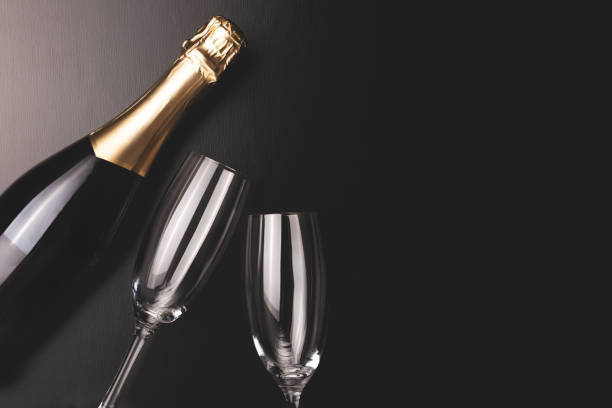 composizione minimale con bottiglia di champagne e due bicchieri. - champagne celebration glass black foto e immagini stock