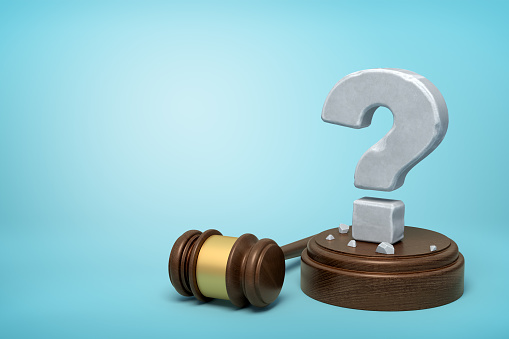 3d rendering of hefty stone question mark standing on sounding block with gavel beside on light-blue background with copy space. Lawsuit and trials. Guilty or innocent? Controversial court case.