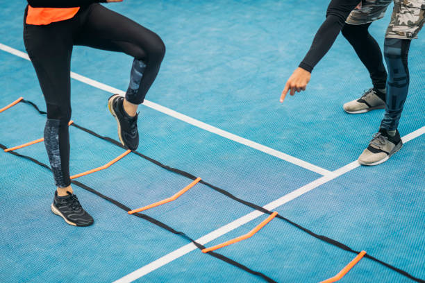 Young Woman Exercise using Agility Ladder, working with Fitness Coach