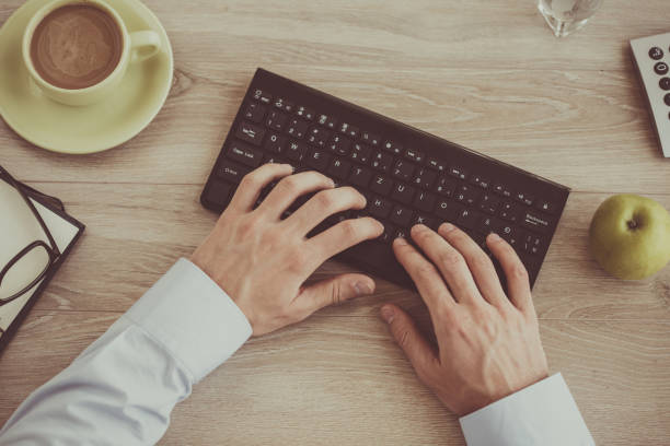 istock Cut out of man typing on keyboard 1180393898