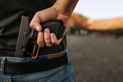 El hombre sosteniendo un arma corta escondida en su mano. photo