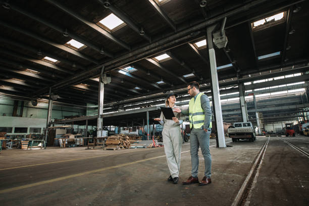 istock Manager touring with female worker at large industrial building. 1180394006