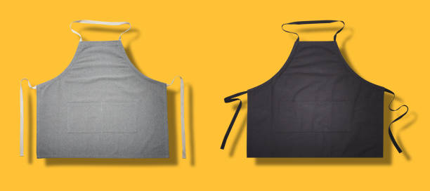 istock Black and gray apron for kitchen top view. Isolated on yellow background. 1180395183