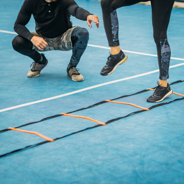 istock Young Woman Exercise using Agility Ladder, working with Fitness Coach 1180396925