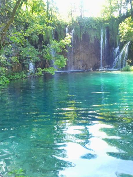 istock Waterfront,turquoise water,waterfall flowing motion,Stone,rock,moss,water splash,plant,grass,sunbeam,Plitvije,Croatia 1180398182