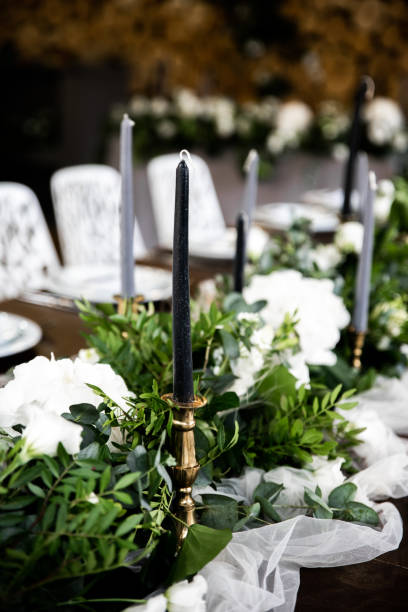istock Gray candles in candlesticks among greenery on the festive table 1180402762