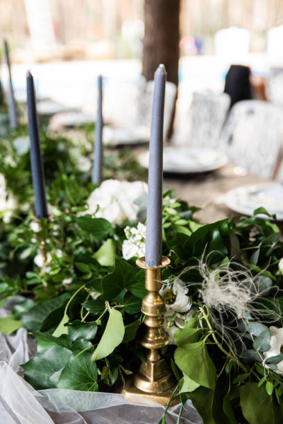 istock Gray candles in gold candlesticks among greenery on the festive table 1180402771