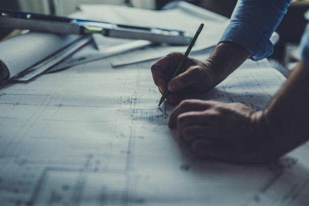 Engineer working late Hand drawing on a blueprint hand drawing stock pictures, royalty-free photos & images