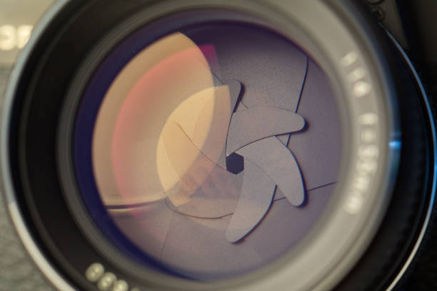 istock Vintage lens front element close up macro shot with light reflections and visible closed  aperture blades 1180404738