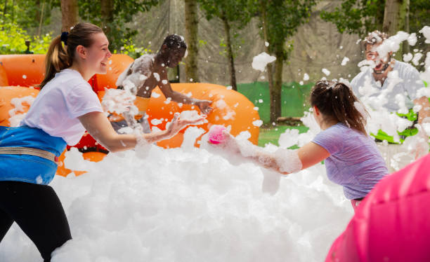 istock Friends picking up balls in inflatable pool with foam 1180408537