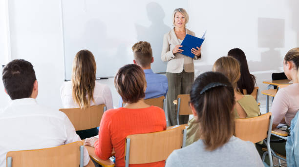 istock Female teacher lecturing to students 1180408703