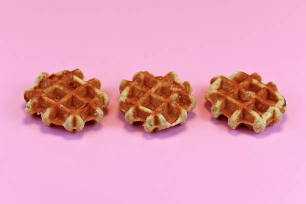 istock Three round waffles in a row on light pink background 1180410865