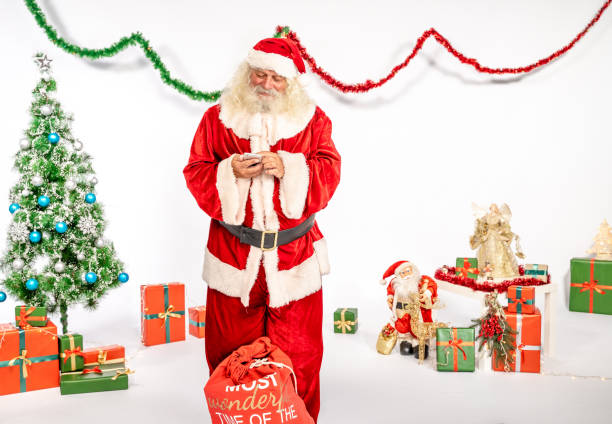istock Santa Claus using smart phone wide shot 1180411935