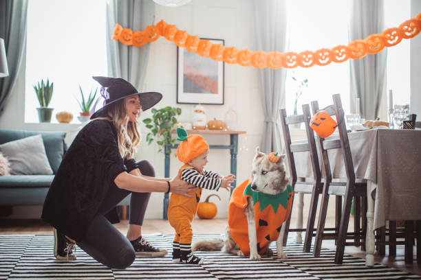 madre ayudando al bebé a caminar en halloween - pets table animal cheerful fotografías e imágenes de stock