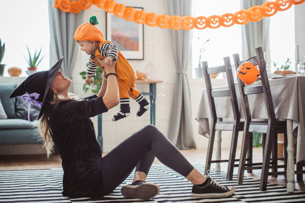 istock Mother helping baby playing on Halloween 1180412672