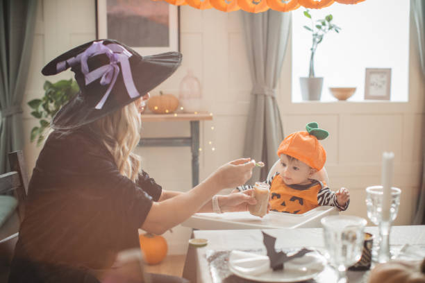 istock Mother feeding baby on Halloween 1180412696
