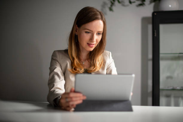 istock Young woman typing on digital tablet in her office 1180414185