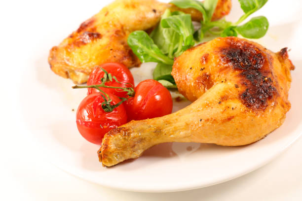 istock grilled chicken leg and tomato isolated on white background 1180416859