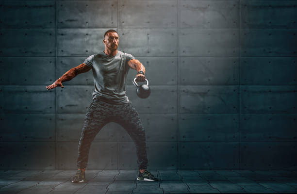 uomini muscolosi forti, allenamento incrociato atleta esercizio con kettlebell. copia spazio - cross training foto e immagini stock