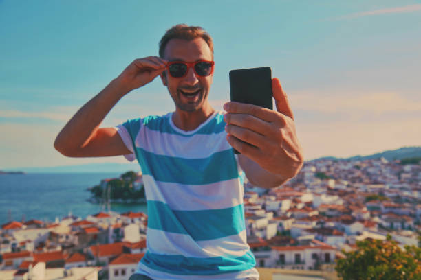 istock Attractive man using cellphone outdoors. 1180417569