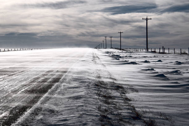 Snow blowing across an asphalt highway