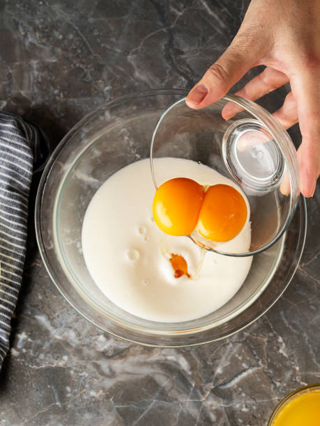 Mixing milk and eggs,Crack open egg,Woman Preparing Pancakes,Preparing Pancakes, Cracking of raw chicken egg into the bowl,