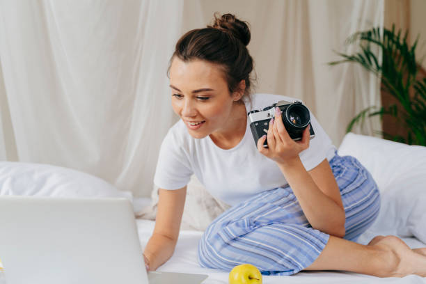 istock Smiling young woman is looking on screen 1180420584