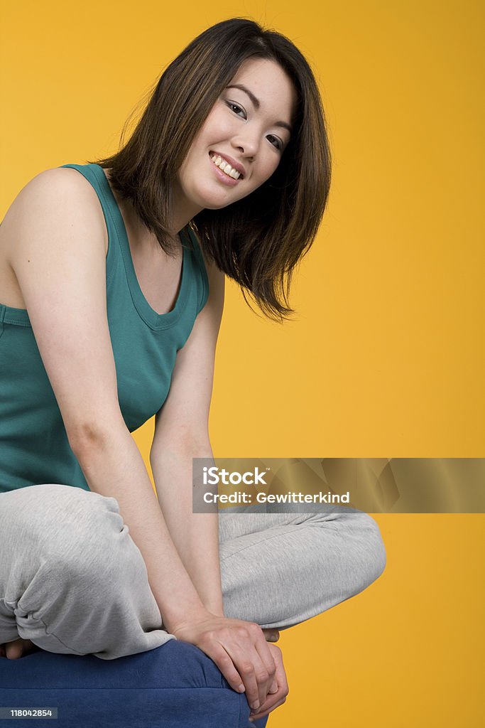 Joven mujer asiática en frente de fondo amarillo - Foto de stock de 20-24 años libre de derechos