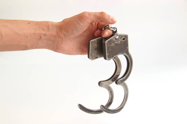 istock handcuffs in hand isolated on white background 1180430350