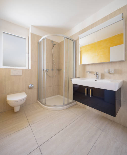istock Bathroom with toilet, cabinet with sink and mirror and shower 1180432714