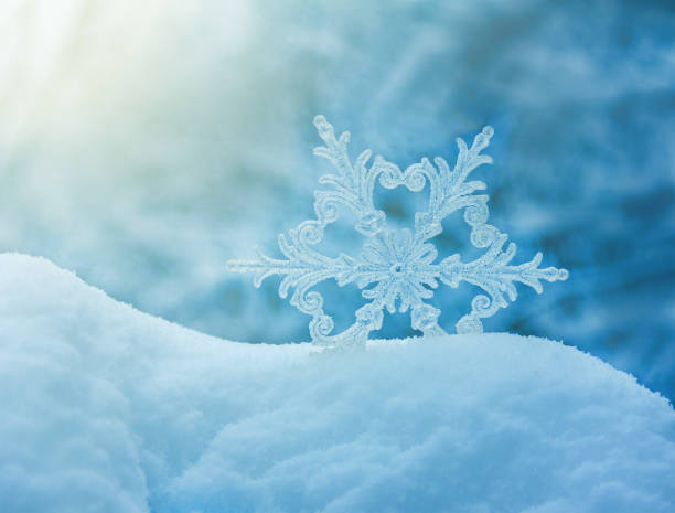 istock large snowflake in a snowdrift on a blue background closeup 1180434568