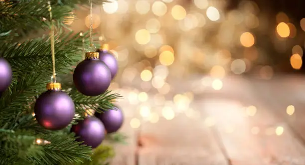 Photo of Christmas Tree with Purple Baubles and Gold Lights Background