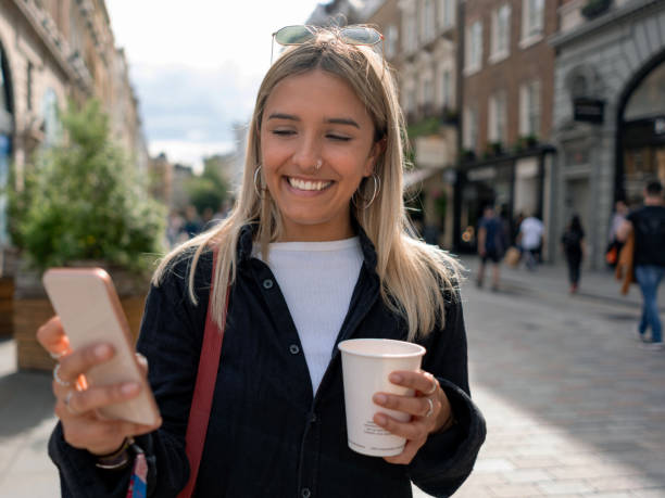 istock Happy woman using app on her cell phone outdoors 1180435389
