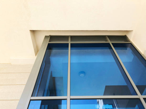 istock Facade of modern building with rectangular turquoise glass bay windows front view. 1180435467