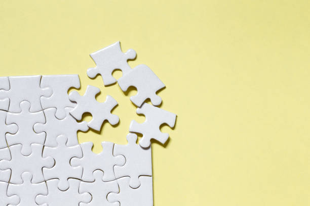 Closeup jigsaw puzzle white piece on yellow backdrop