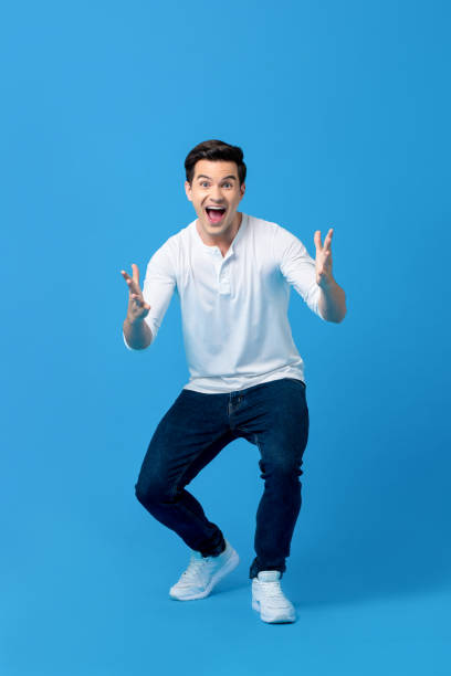 Young caucasian man in surprised gesture Young caucasian man in surprised gesture with opening hand and mouth on light blue background male meaning stock pictures, royalty-free photos & images
