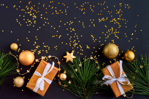 istock Flat lay border with gold christmas balls and gift box on a dark background 1180444758