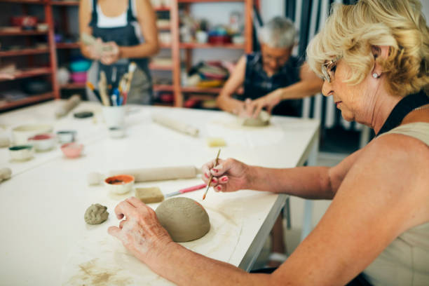 istock Senior Women Decorating Ceramics Bowl At Ceramics Workshop 1180447227