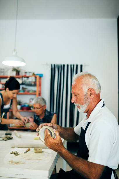 istock Senior Man Making Ceramics Bowl At Ceramics Workshop 1180447250