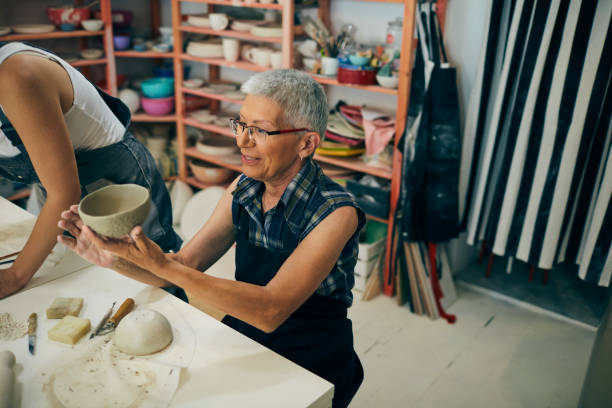 istock Senior Woman Decorating Ceramics Bowl At Ceramics Workshop 1180447355