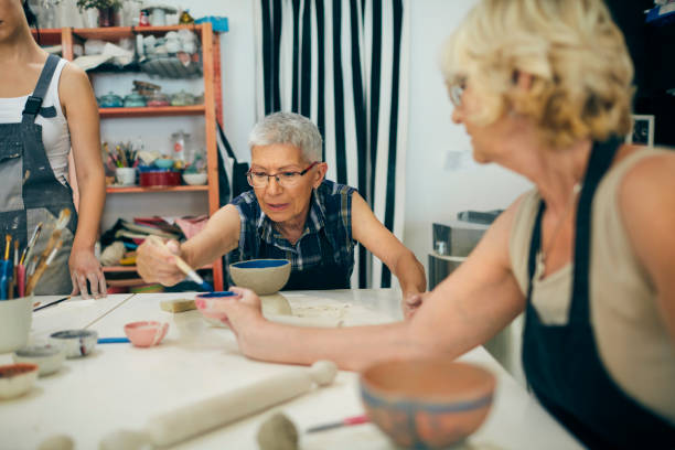 istock Senior Women Decorating Ceramics Bowl At Ceramics Workshop 1180447420